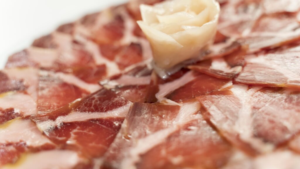 Plato de jamón ibérico de bellota recién cortado, una tapa auténtica en Madrid, como alternativa a la cena incluida en un tablao flamenco.